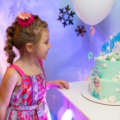 ребенок смотрит на праздничный торт